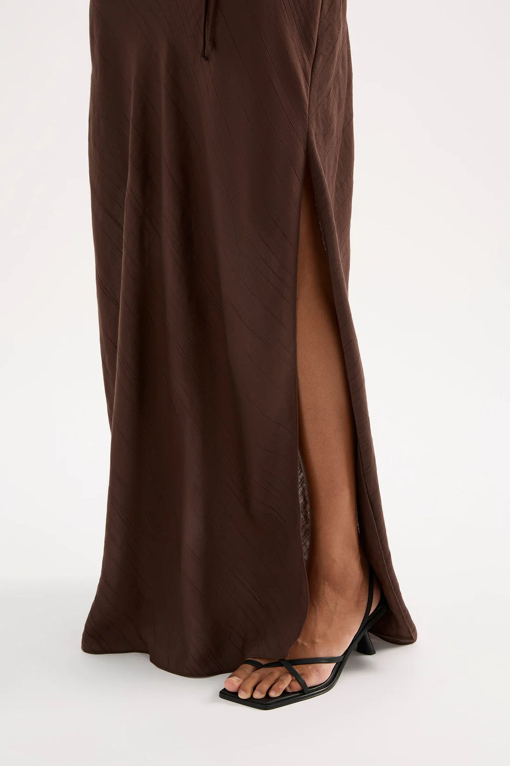 Brown maxi skirt with a slit on a white background